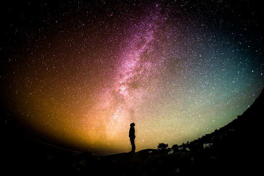 Person, standing and looking up into the stars and the Milky Way. 